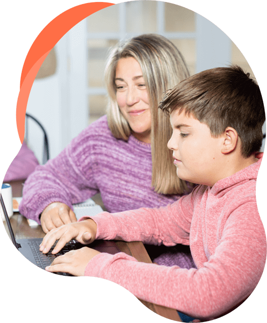 Mother who is homeschooling her son watches him do an assignment on his laptop